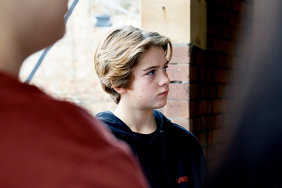 young guy in group with neutral expression